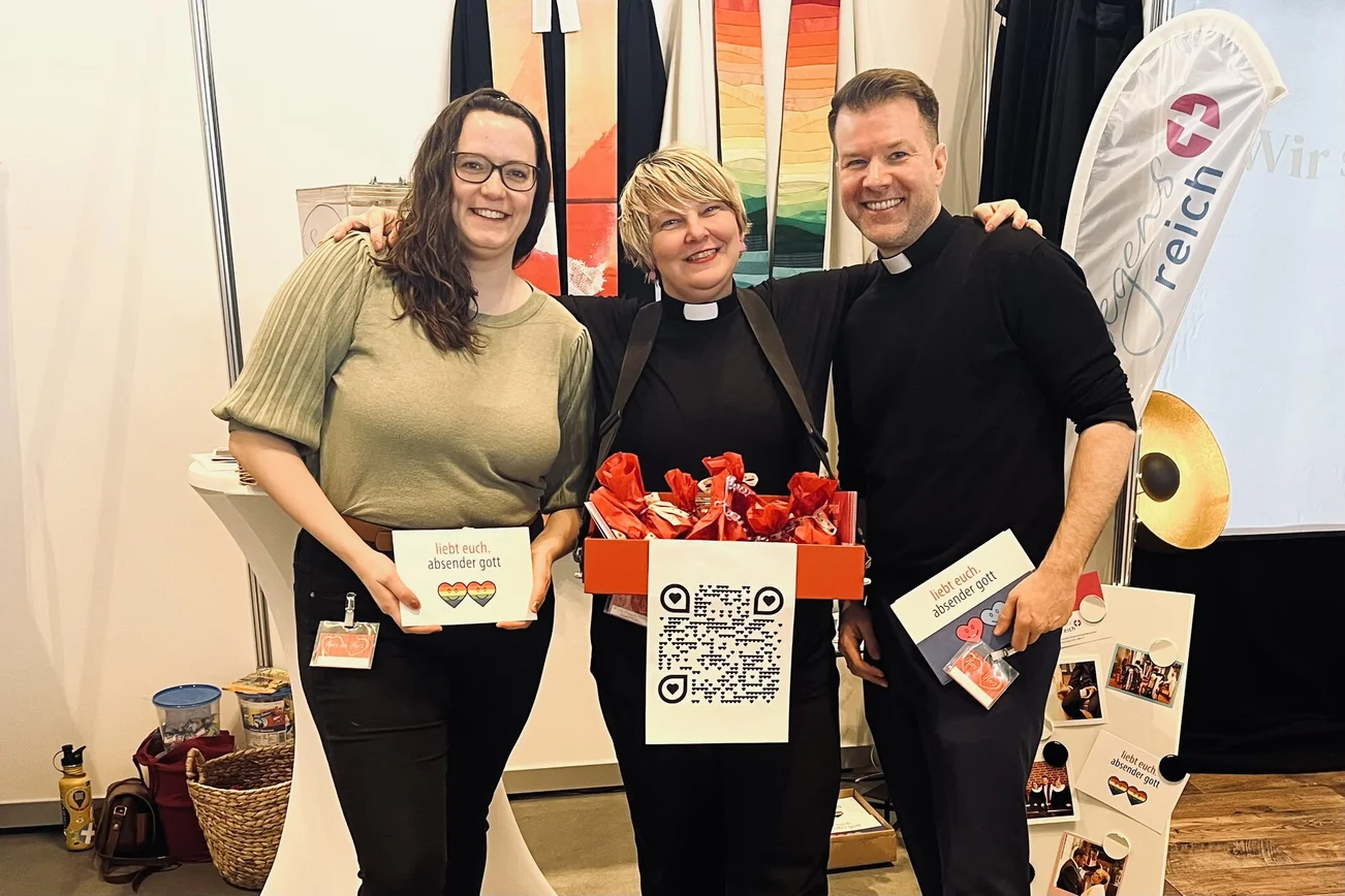 Drei Menschen lächeln in die Kamera.